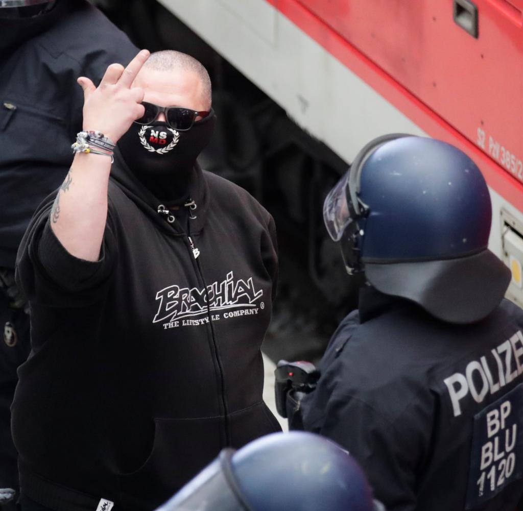 Ein angekommener Mann wird in Dresden eingecheckt - das Symbol auf seiner Maske wird auch von einer Facebook-Gruppe namens genannt 