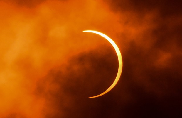 Der Mond bewegt sich während einer ringförmigen Sonnenfinsternis, die am 21. Juni 2020 durch die Wolken von Neu-Delhi gesehen wird, an der Sonne vorbei