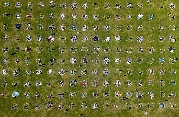 TOPSHOT - Eine Luftaufnahme zeigt Menschen, die sich in gemalten Kreisen auf Gras versammelt haben, um die soziale Distanzierung im Dolores Park in San Francisco, Kalifornien, am 22. Mai 2020 inmitten der neuartigen Coronavirus-Pandemie zu fördern