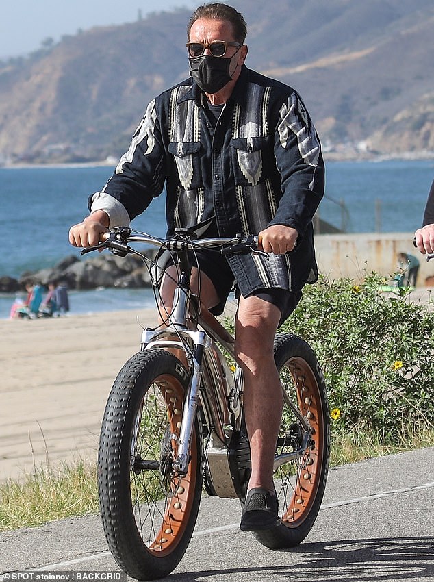 Retro-Stil: Er knöpfte ein schickes Oberteil aus den 1970er Jahren in Gold, Silber und Schwarz über ein schlichtes schwarzes T-Shirt und eine passende Fahrradshorts