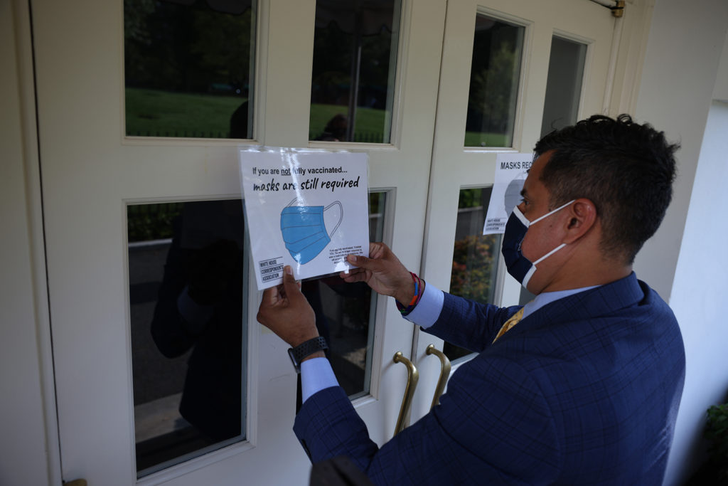  Fin Gomez, a journalist with CBS News and White House Correspondents Association board member, replaces signs for mask-wearing guidance around the James Brady Press Briefing Room at the White House on July 27, in Washington, DC.