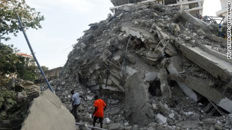 Menschen marschieren, um Arbeiter aus den Trümmern des eingestürzten Gebäudes in Lagos, Nigeria, zu retten. 