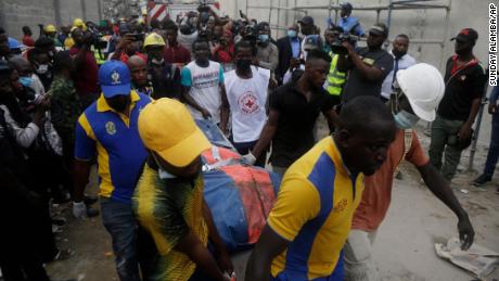 Rettungskräfte transportieren eine Leiche zum Ort eines eingestürzten Gebäudes im Bau in Lagos, Nigeria. 