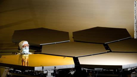Der Optiktechniker von Ball Aerospace, Scott Murray, inspiziert das erste goldene Hauptspiegelsegment des Teleskops.