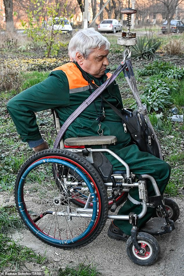 Herr Yudin, 69, befestigt sich sicher am Fahrzeug, bevor er beginnt, es vom Boden zu heben