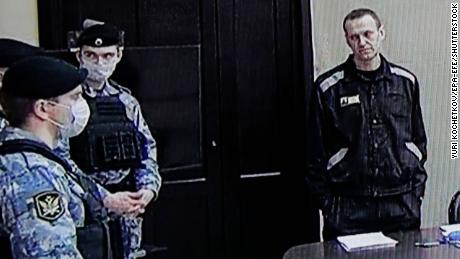 Der russische Oppositionsführer und Aktivist Alexei Nawalny (rechts) ist auf einem Bildschirm während einer Anhörung außerhalb des Geländes in der Strafkolonie Pokrov in der russischen Region Wladimir am 22. März zu sehen.