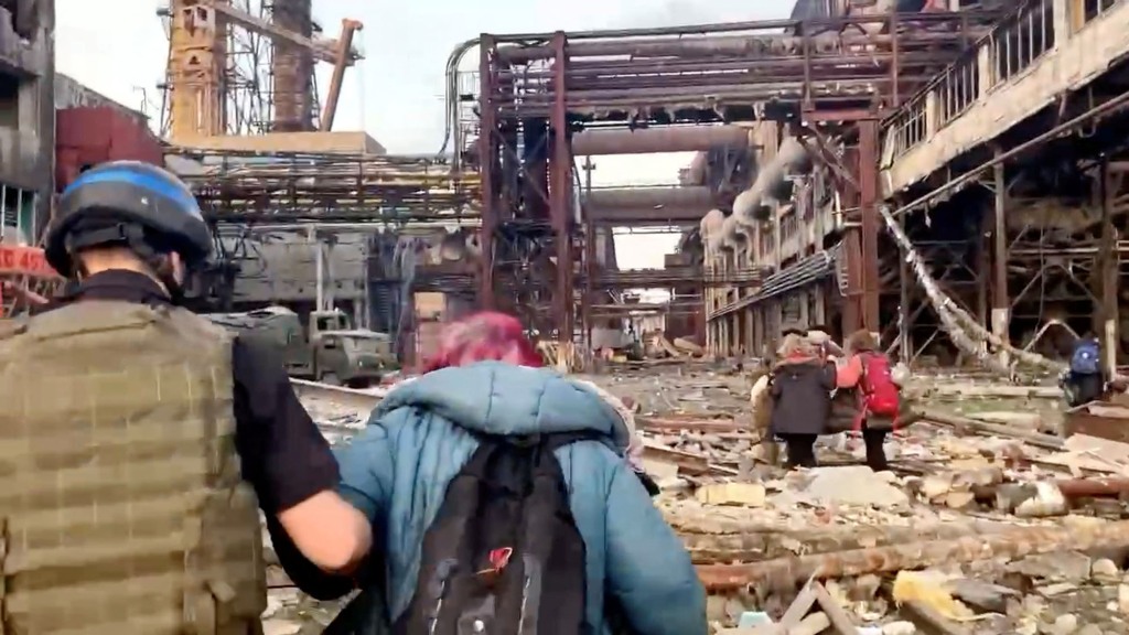 Mitglieder des Azov-Regiments marschieren mit Zivilisten während der UN-geführten Evakuierungen des weitläufigen Azovstal-Stahlwerks nach fast zwei Monaten Belagerungskrieg gegen die Stadt durch Russland während seiner Invasion in Mariupol, Ukraine, in diesem Standbild aus einem Video, das am 1. 2022. 