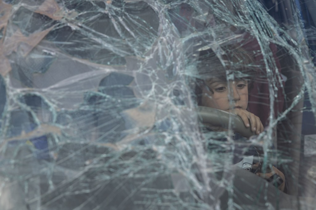 Ein Junge aus Mariupol schaut durch die kaputte Windschutzscheibe des Autos seiner Familie