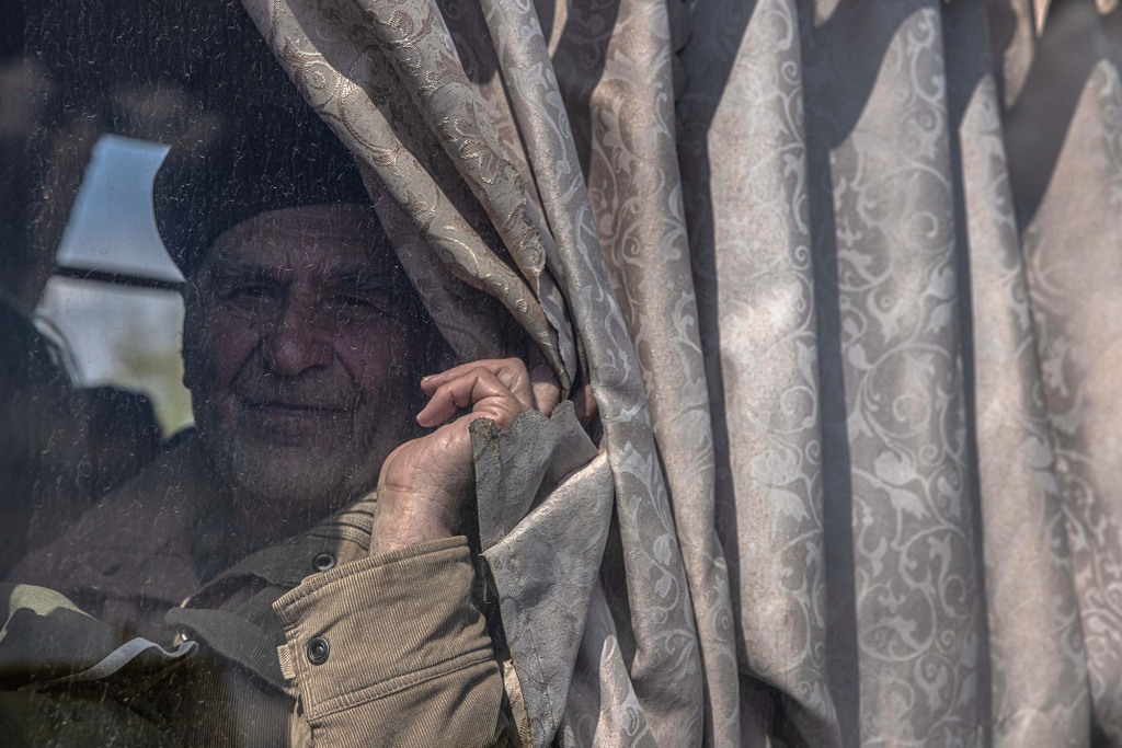 Ein älterer Mann sieht zu, wie er in einem Bus sitzt, nachdem er von der Frontstadt Orikhiv zum Evakuierungspunkt in Saporischschja in der Ukraine gelangt ist