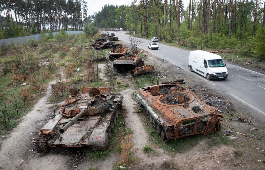 Autos fahren an russischen Panzern vorbei, die kürzlich in einem Kampf mit Ukrainern im Dorf Dmytrivka zerstört wurden.