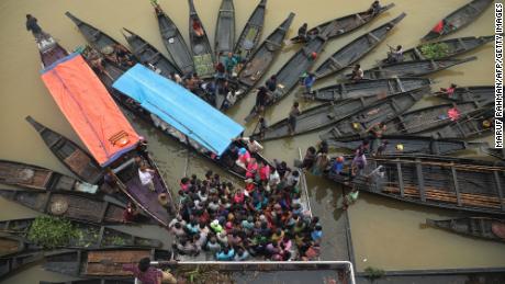 Menschen versammeln sich am Montag in einem überschwemmten Gebiet in Companiganj, Bangladesch, um Nahrungsmittelhilfe zu sammeln. 