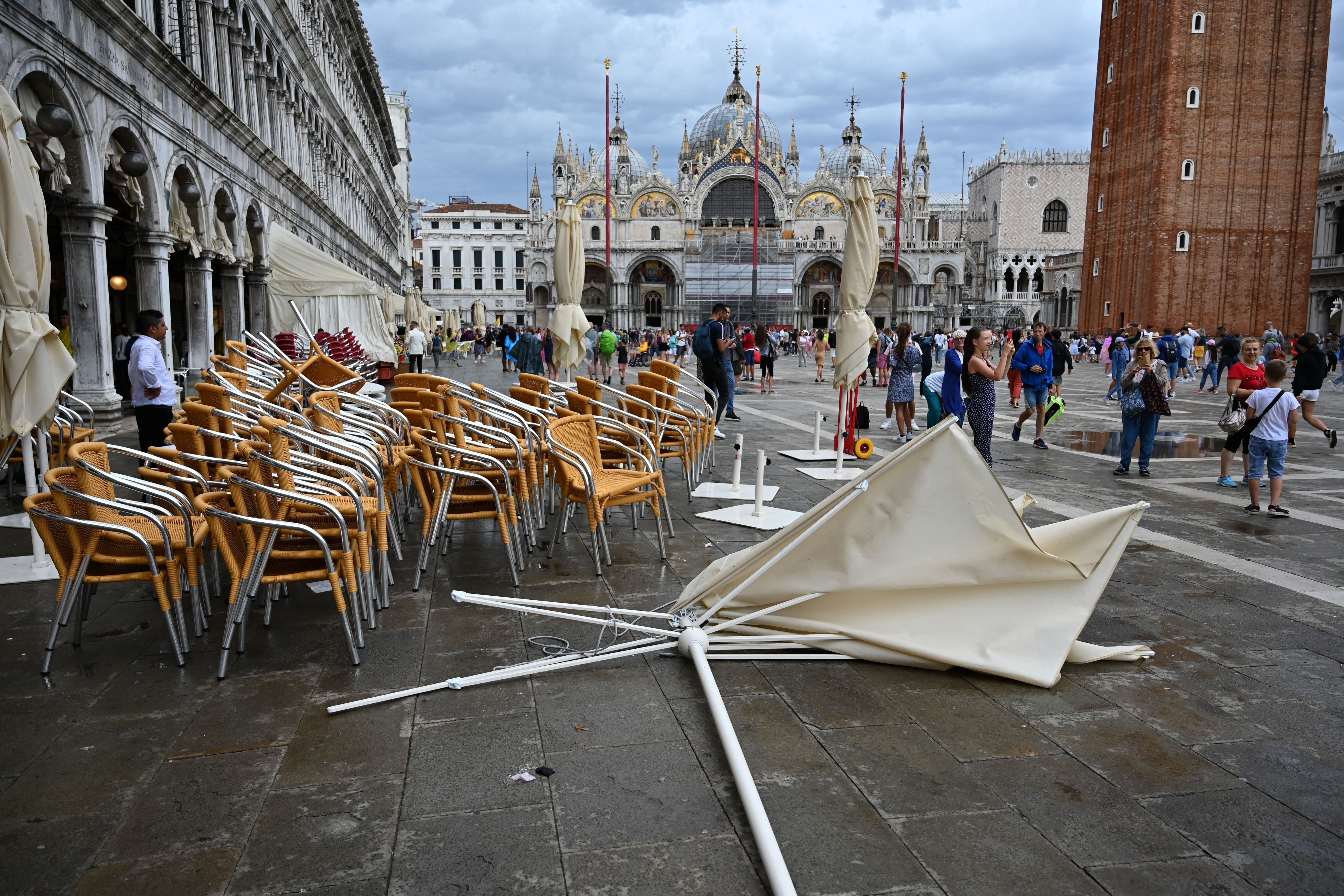 Auf der Terrasse der Bar Eden auf dem Markusplatz in Venedig liegt am 18. August 2022 wegen schlechten Wetters ein Sonnenschirm auf dem Boden.  