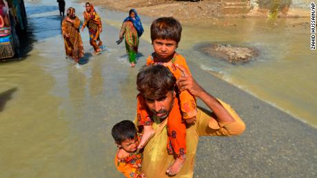 Am Samstag trägt ein Vertriebener seine Töchter aus seinem von der Flut betroffenen Haus in Jaffarabad, einem Bezirk der Provinz Belutschistan im Südwesten Pakistans. 