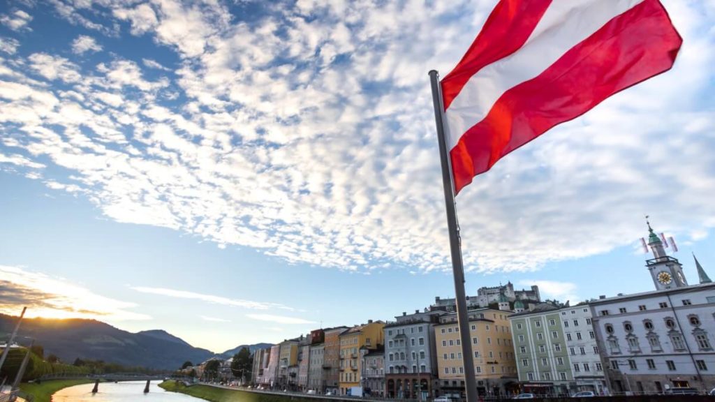 Austrian flag over historic Salzburg cityscape