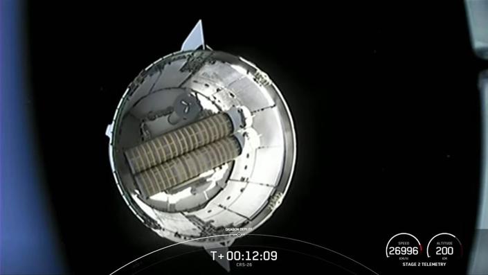 Eine Kamera auf der zweiten Stufe von Falcon 9 fängt einen Blick auf das schwebende Dragon-Frachtschiff ein, nachdem es die Umlaufbahn erreicht hat.  Im drucklosen Rumpfabschnitt des Raumfahrzeugs ist ein Satz aufgerollter Solarpanelabdeckungen sichtbar.  / Bildnachweis: NASA-Fernsehen