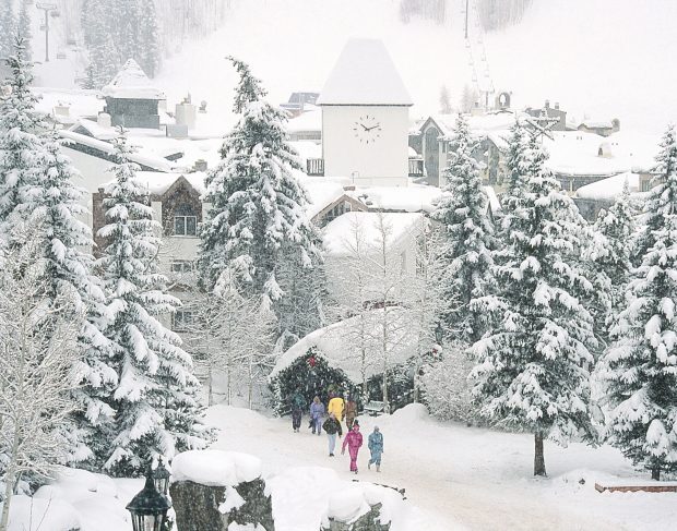 Menschen gehen durch das Dorf Vail und durch seine hölzernen Zügel im Schnee.  Angeboten vom Gasthof Gramshammer
